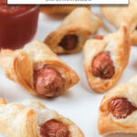 cooked pigs in a blanket on white plate with text overlay 