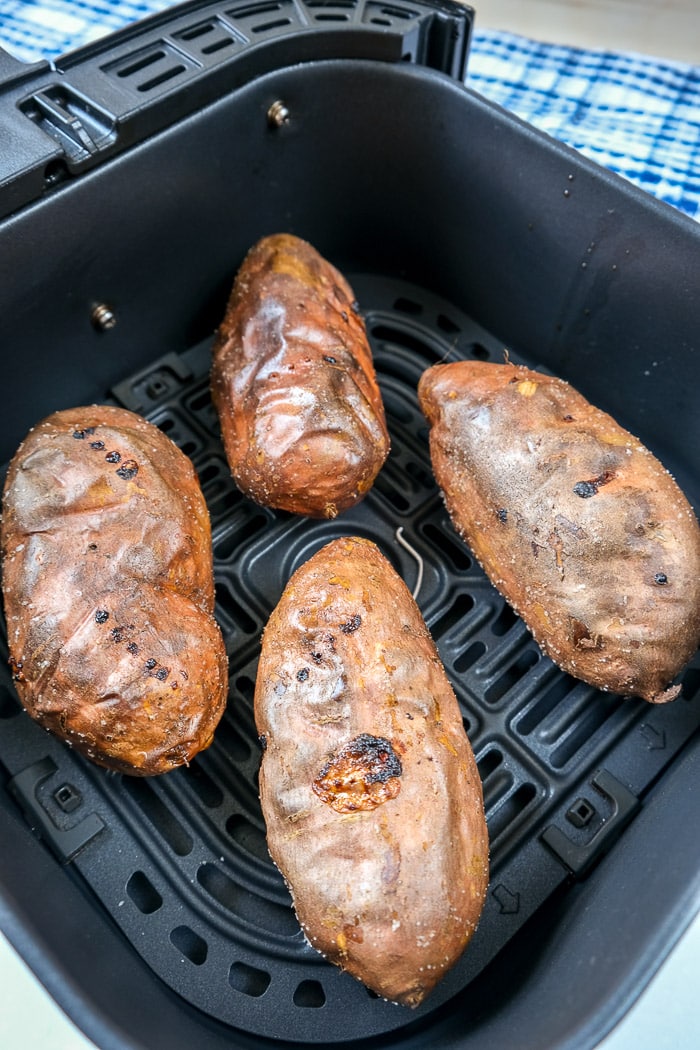 cooked sweet potatoes in black air fryer tray on counter top