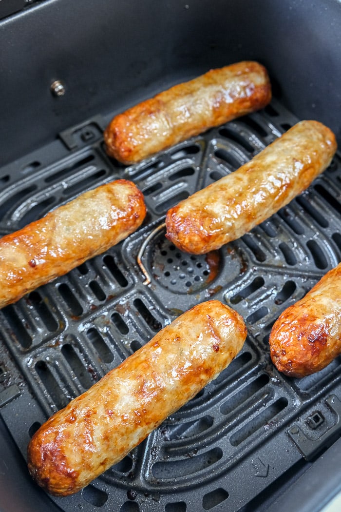 cooked chicken sausages in black air fryer tray
