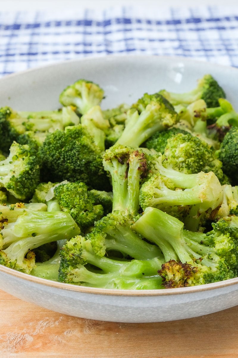 green cooked broccoli in bowl on wooden board