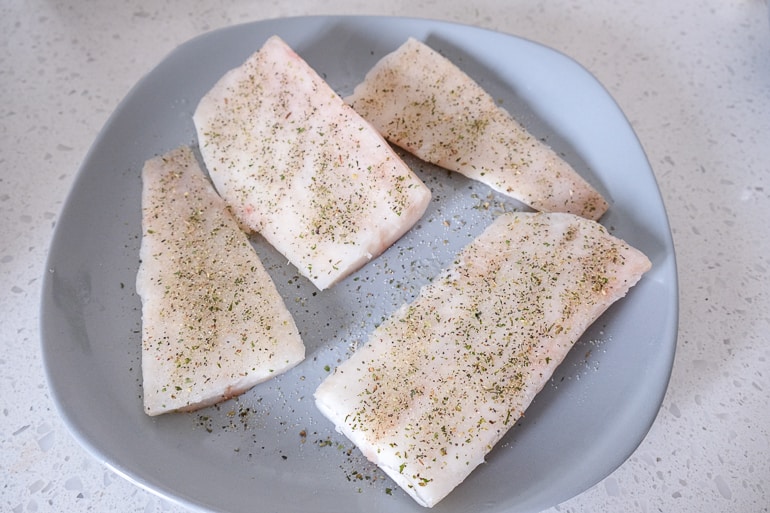 frozen fish fish fillets on grey plate covered in spices