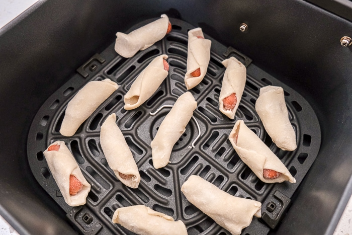 frozen raw pigs in blankets in black air fryer tray