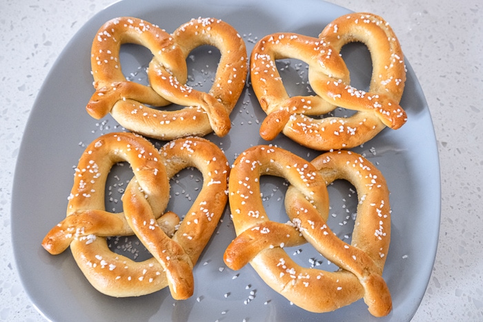 frozen pretzels with salt on grey plate on white counter