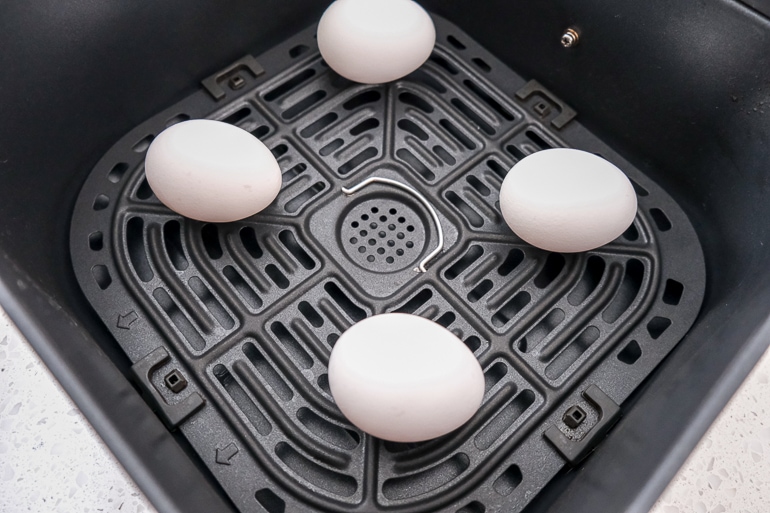 eggs in black air fryer tray on white counter