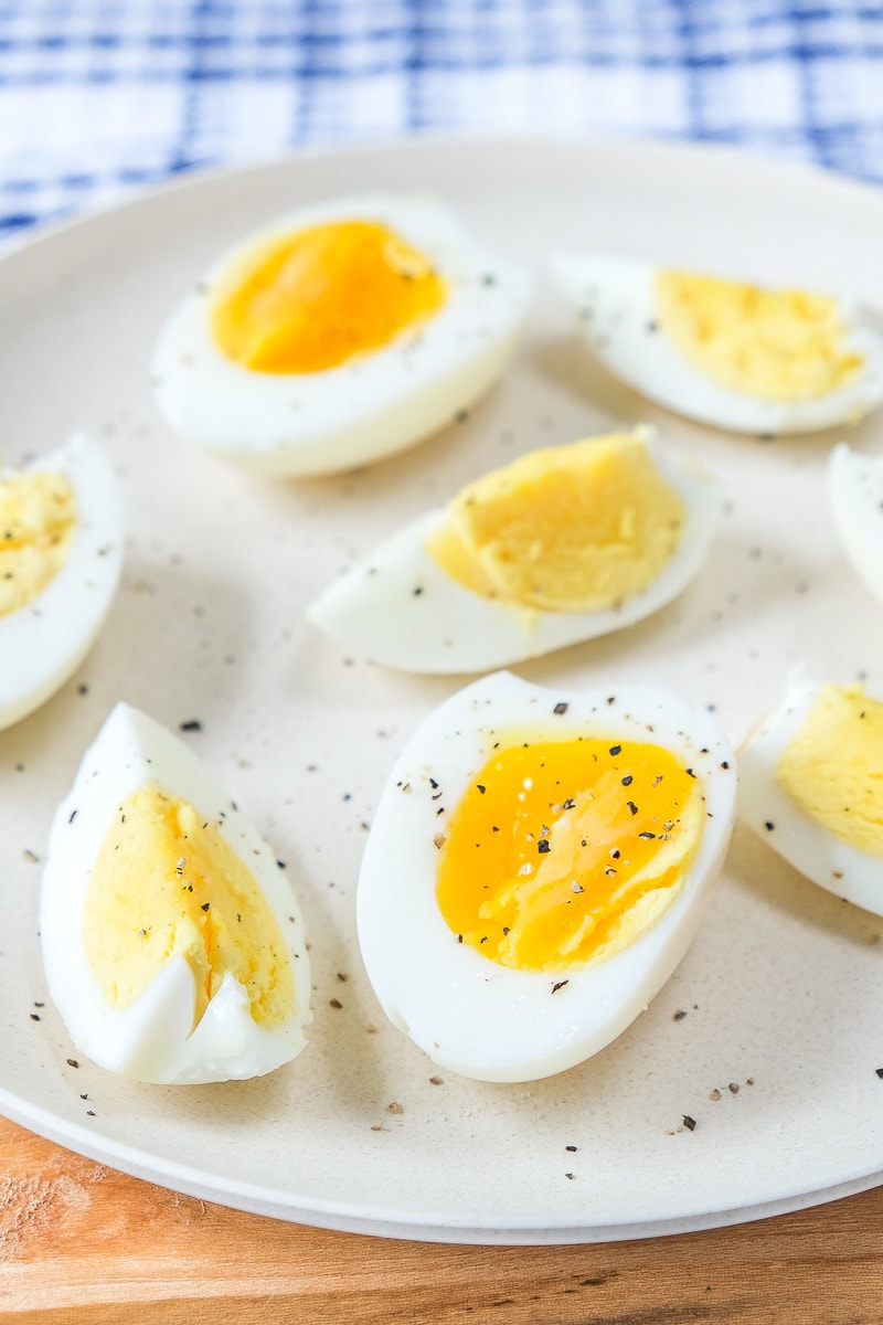 hard boiled eggs cut up on white plate with pepper