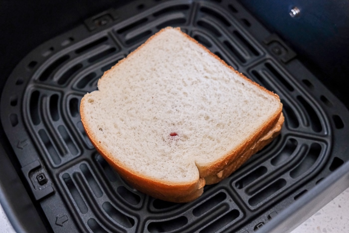 untoasted peanut butter and jam sandwich in air fryer tray