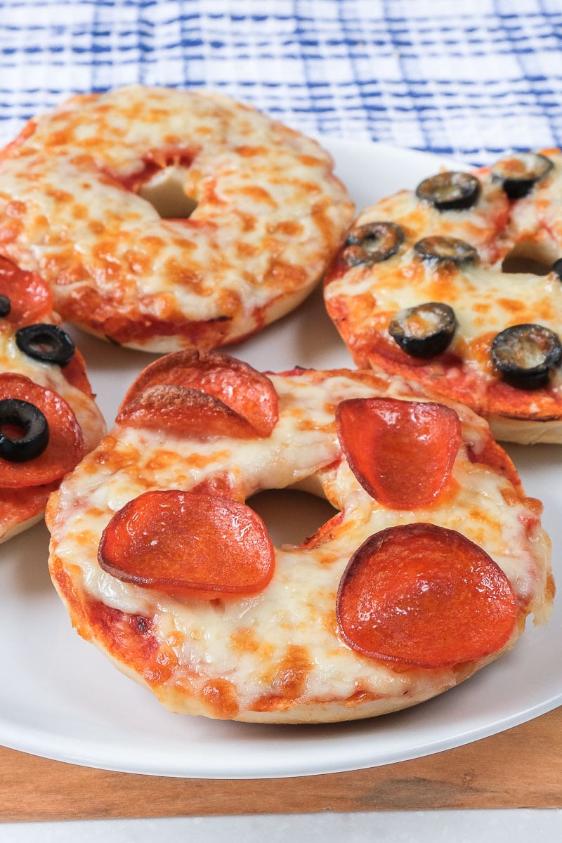 pizza bagels with cheese and pepperoni on white plate