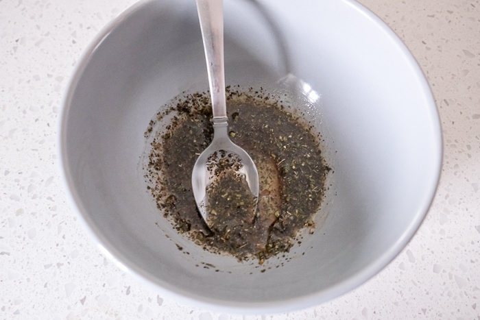 spice mix in bowl being stirred with silver spoon