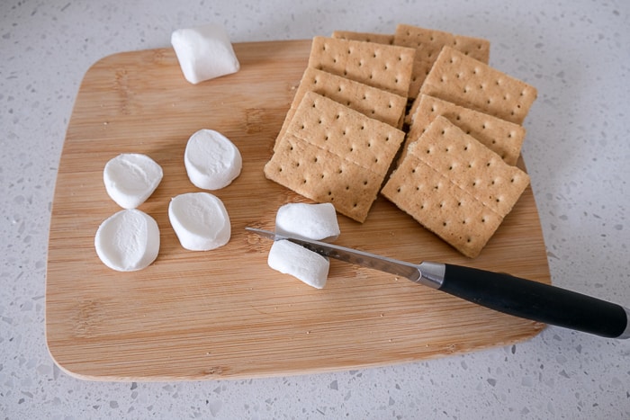 knife cutting marshmallow in half on wooden board