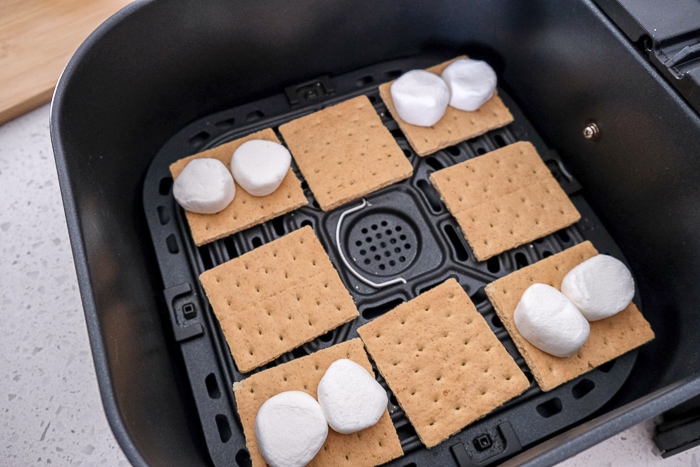 graham crackers and marshmallows in black air fryer tray on white counter