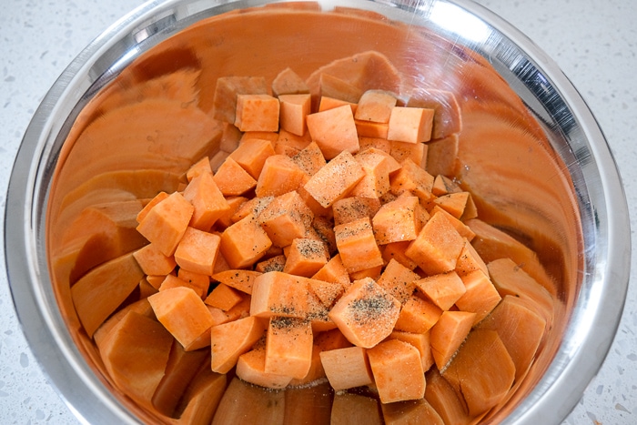 sweet potato cubes in silver bowl on white counter