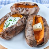 baked sweet potatoes on white plate with wooden underneath