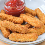 chicken fries in bowl on wood with ketchup behind