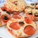 pizza bagels with cheese and pepperoni on white plate
