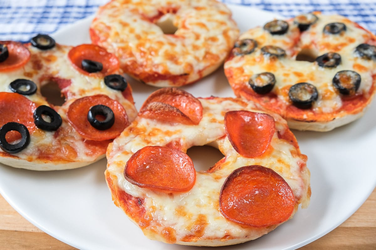 pizza bagels with cheese and pepperoni on white plate