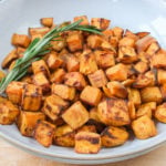 orange sweet potato cubes in bowl on wooden board