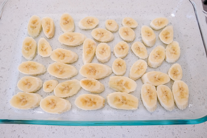 banana slices in glass pan on white counter