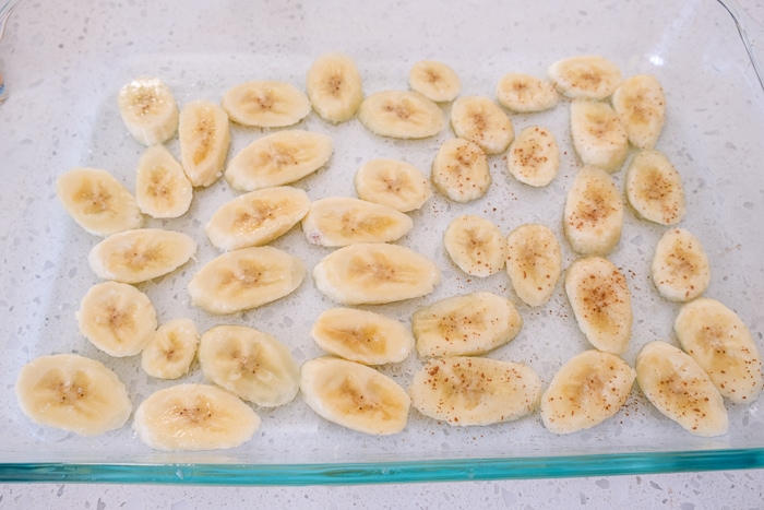 banana slices in glass pan on white counter top