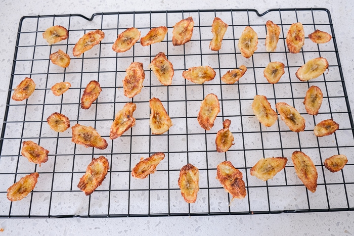 banana chips on black cooling rack on white counter top
