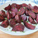 cooked beet slices on white plate on wooden board