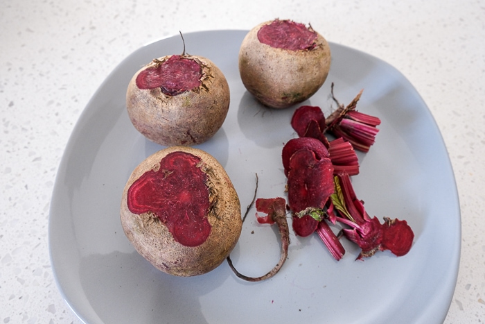 raw beets on grey plate with tops cut off