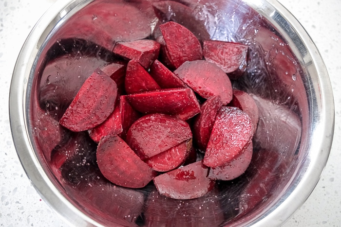 raw beets in silver bowl covered in oil and spices