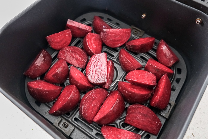 raw beets in black air fryer tray on white counter