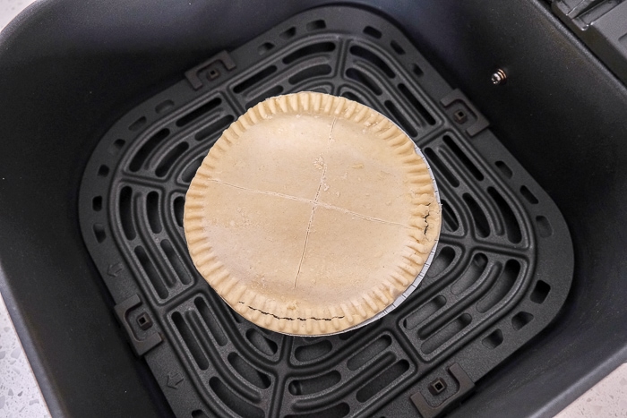uncooked pot pie in black air fryer tray