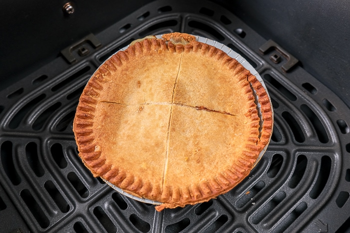 cooked pot pie with flakey crust in black air fryer tray