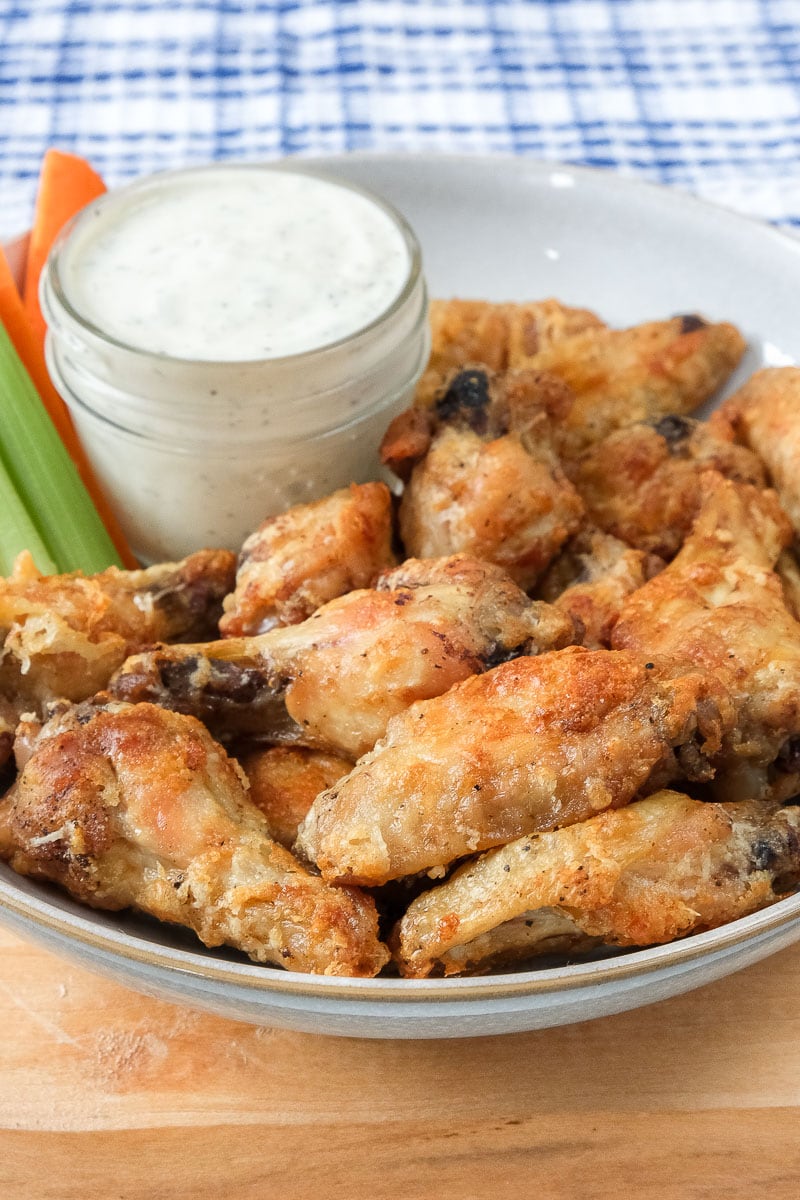 parmesan chicken wings in bowl with dip and cut celery behind