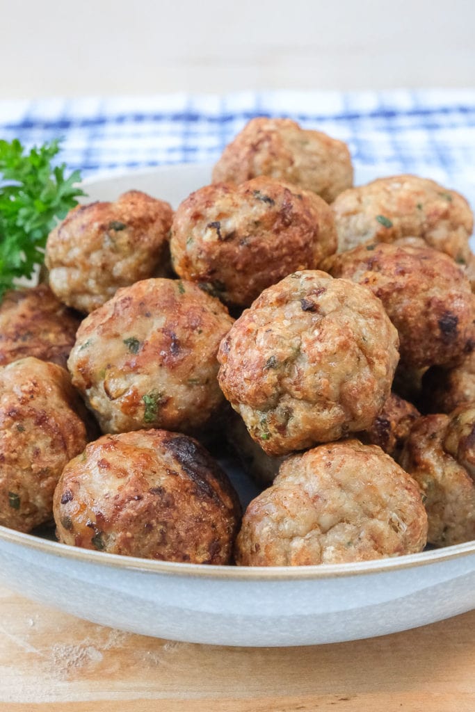 cooked turkey meatballs in bowl on wooden board