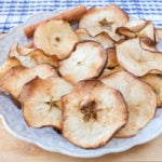 apple chips on plate sitting on wooden board