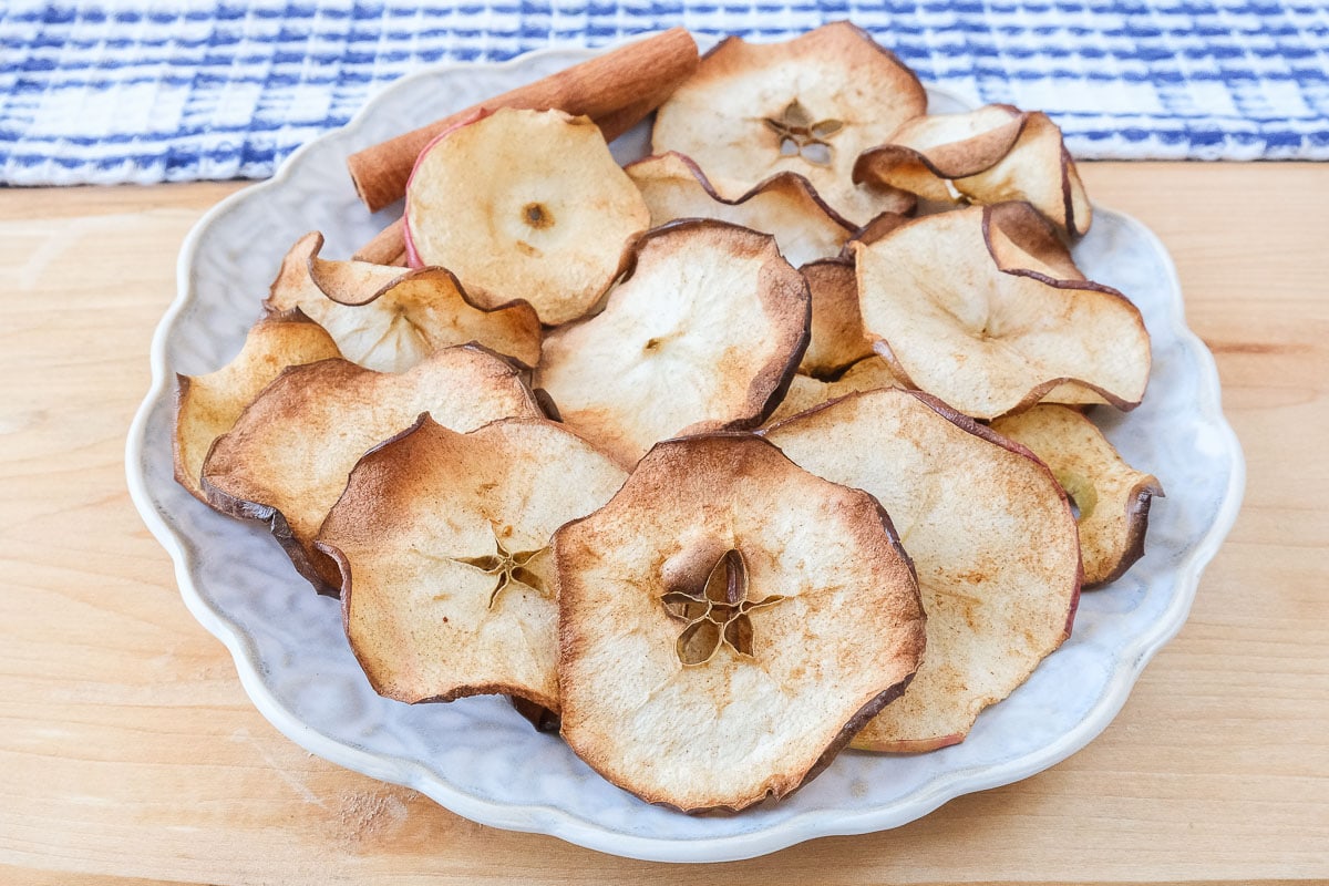 apple chips on plate sitting on wooden board