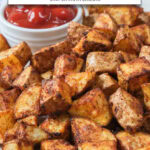 cooked breakfast potatoes on plate with ketchup and text overlay "breakfast potatoes in the air fryer",