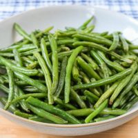 green beans in bowl on wooden board