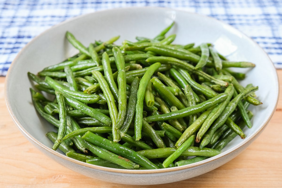 green beans in bowl on wooden board