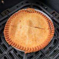 cooked pot pie in black air fryer tray