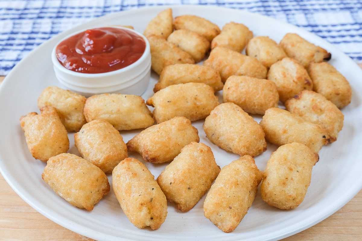 veggie tots on white plate with ketchup dipping sauce