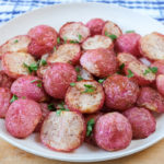 cooked radishes on white plate on wooden board