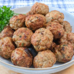 turkey meatballs in bowl on wood with parsley beside
