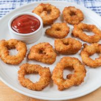 crispy calamari rings on white plate with ketchup dipping bowl beside