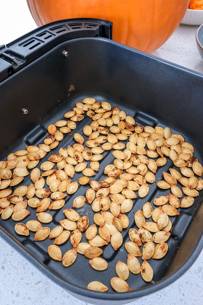roasted pumpkin seeds in black air fryer tray on counter