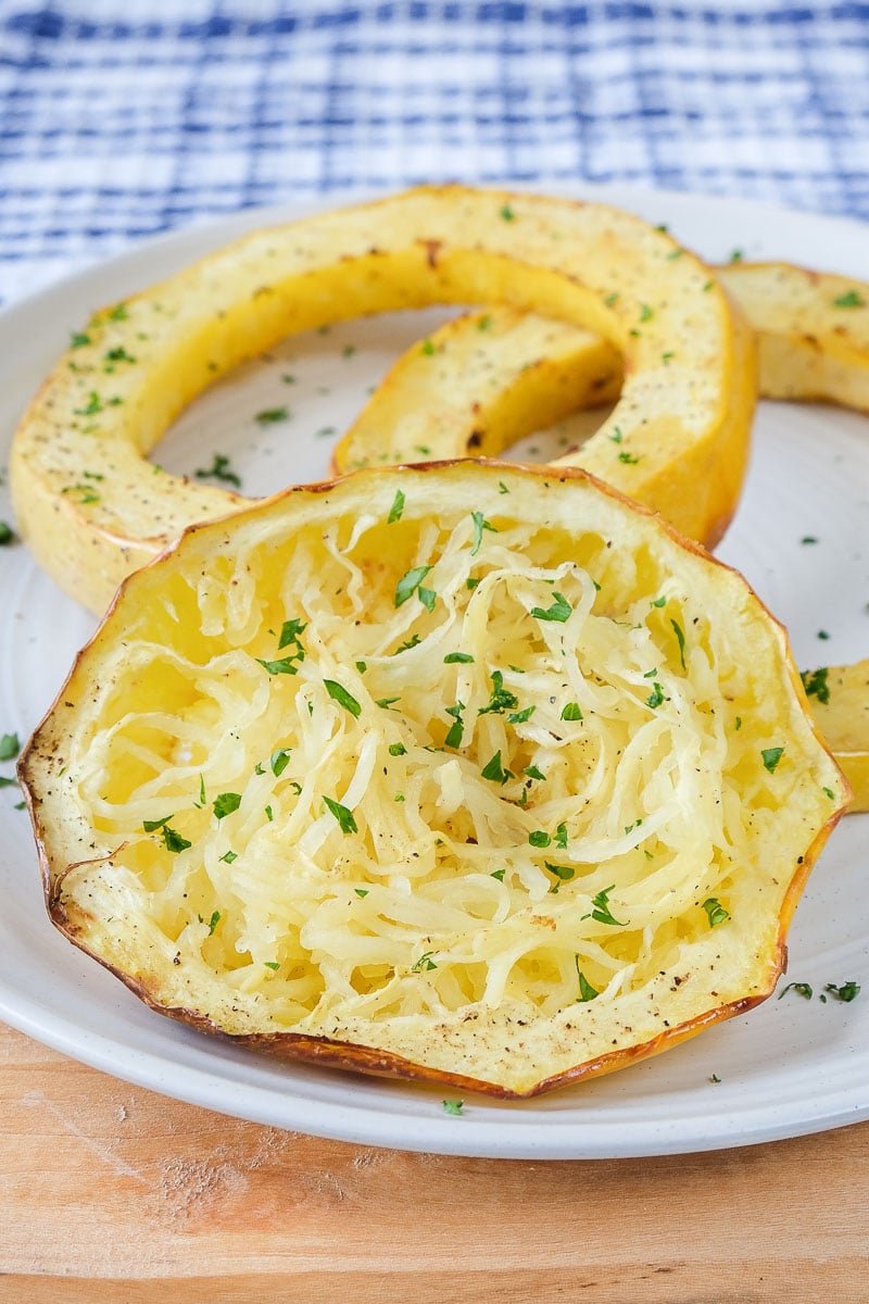 yellow spaghetti squash rings on white plate with parsley
