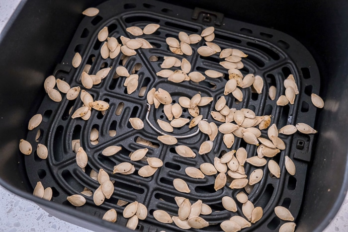 uncooked spaghetti squash seeds in black air fryer tray