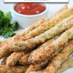 cooked breaded asparagus fries on plate with text overlay "asparagus fries in the air fryer".