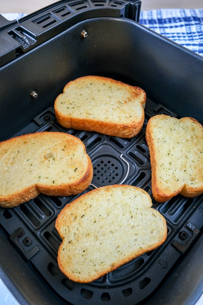 toasted pieces of texas toast in black air fryer tray on counter