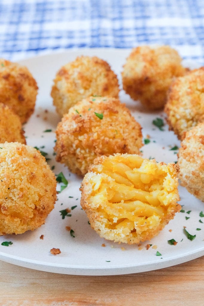 mac and cheese balls on white plate with chopped parsley around