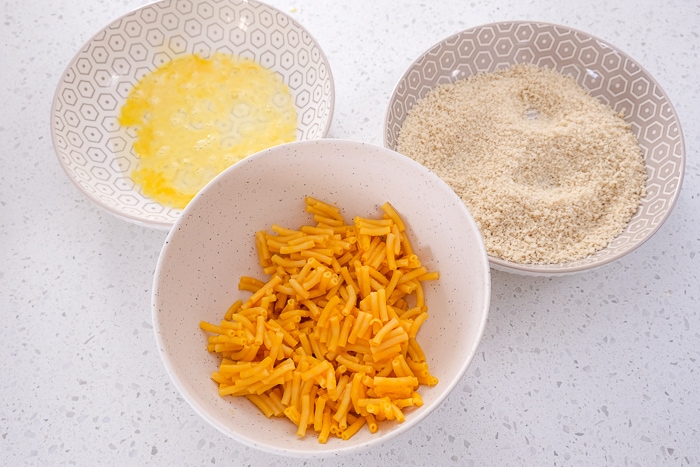 bowls on white counter top of macaroni and cheese egg and breadcrumbs