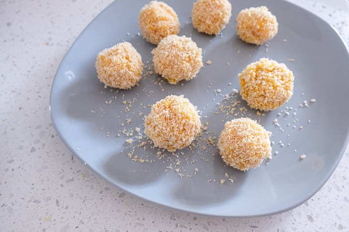 breaded mac and cheese balls on grey plate sitting on white countertop