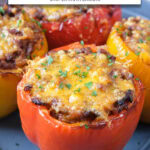 four cooked stuffed peppers with melted cheese in bowl with text overlay "stuffed peppers in the air fryer".